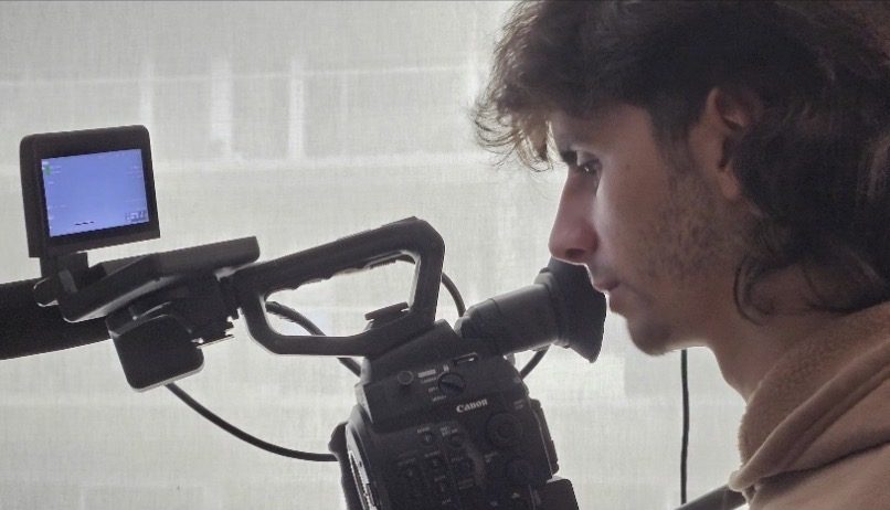 Milo Herbst framing a shot through a Canon cinema camera viewfinder